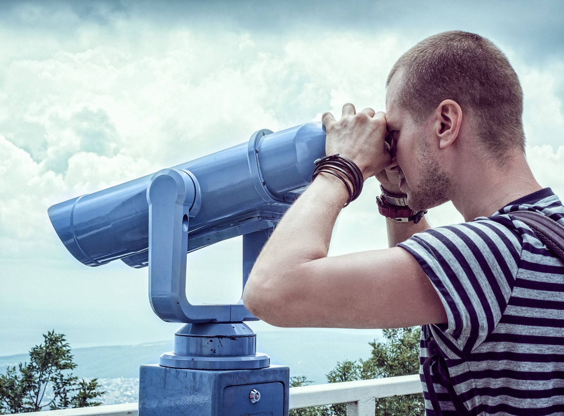 man looking into telescope